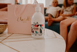 Flacon de savon liquide posé sur une table devant le sac Luxe de Chouette . En arrière plan les enfants sont allongés sur un canapé