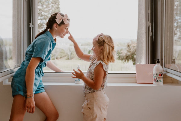 deux petites filles qui jouent à se mettre de la crème sur le nez