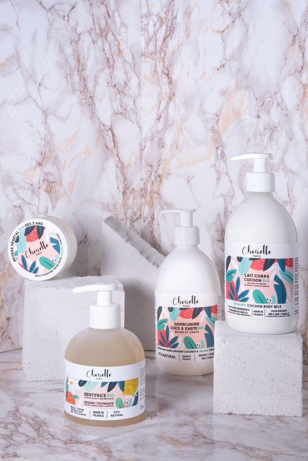 Quatre produits chouette sur plot béton et sur fond marbré
